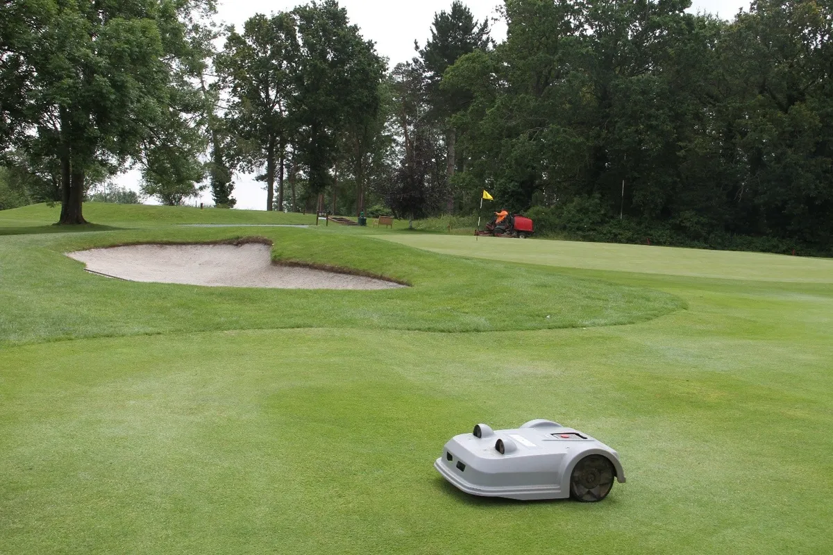 Robotic mower on the course beside a bunker