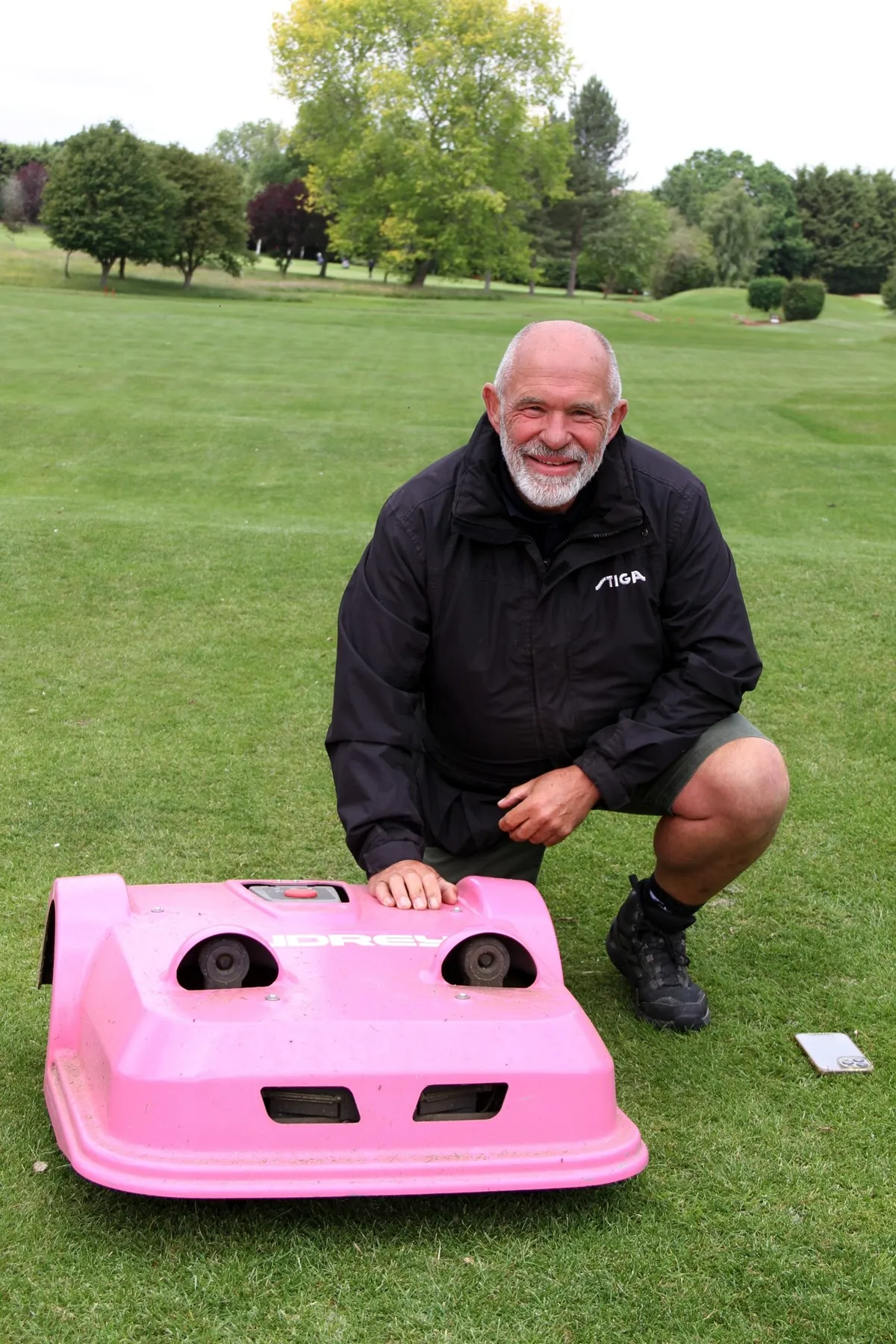Gary Whitney beside a pink robotic mower at Leamington & County Golf Club